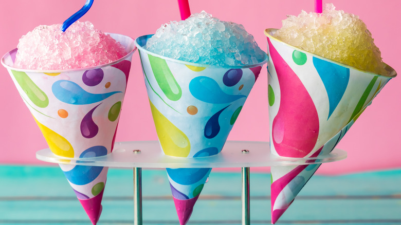Pink, blue, and yellow trio of snow cones with curly strraws