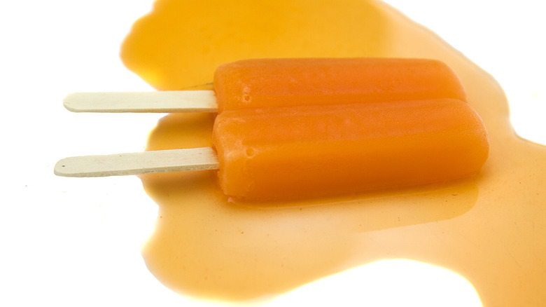 orange twin pop popsicle on orange-colored melty orange juice
