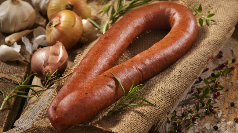 sausage surrounded by garlic, onion, rosemary