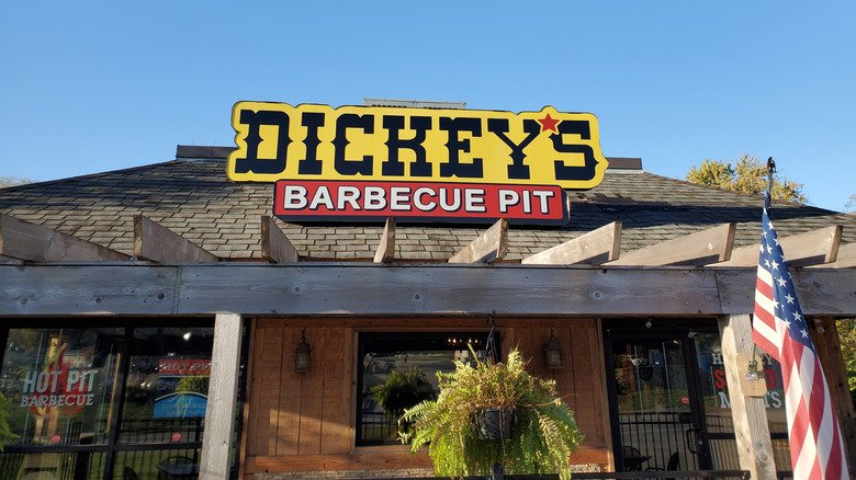 Exterior of a Dickey's Barbecue Pit with a hanging fern and American flag
