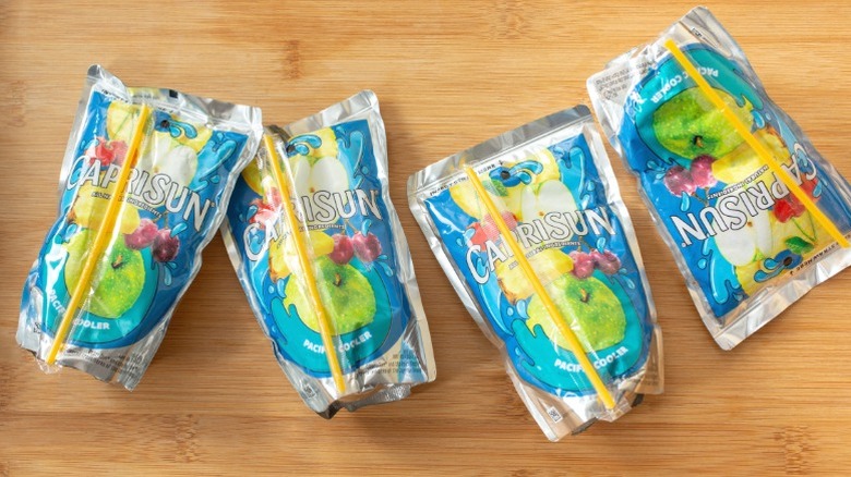 Pouches of Capri-Sun laid out on a wooden counter.