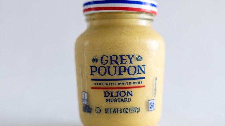 A jar of Grey Poupon Dijon mustard.