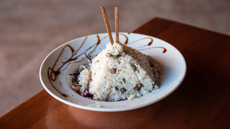 Puerto Rican Arroz con Gandules (Rice and Pigeon Peas) artfully shaped into a pyramid on a garnished plate and served at restaurant.