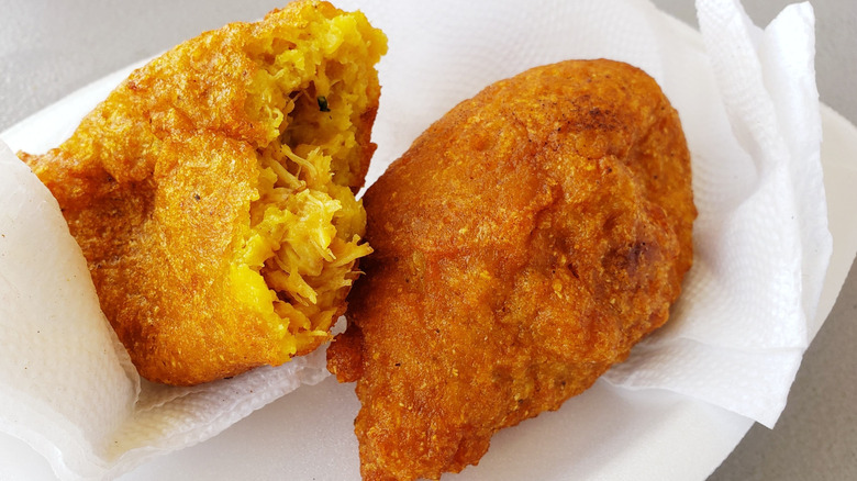 Puerto Rican alcapurrias de jueyes, crispy and golden, filled with seasoned crab meat. Served fresh in paper towel.