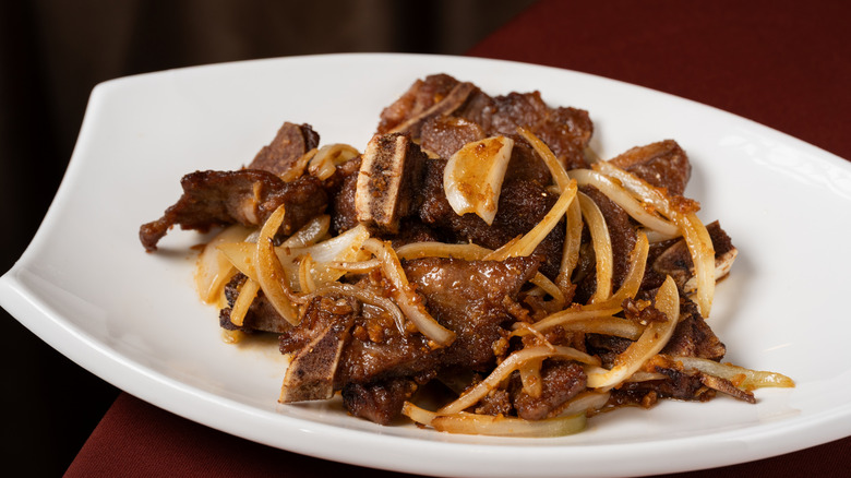 Stir-fried Beef with Onions and garlic on a white plate