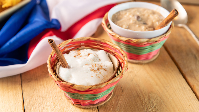 Tembleque and Arroz con leche, traditional Puerto Rican milk and rice puddings in little serving basket bowls with sticks of cinnamon