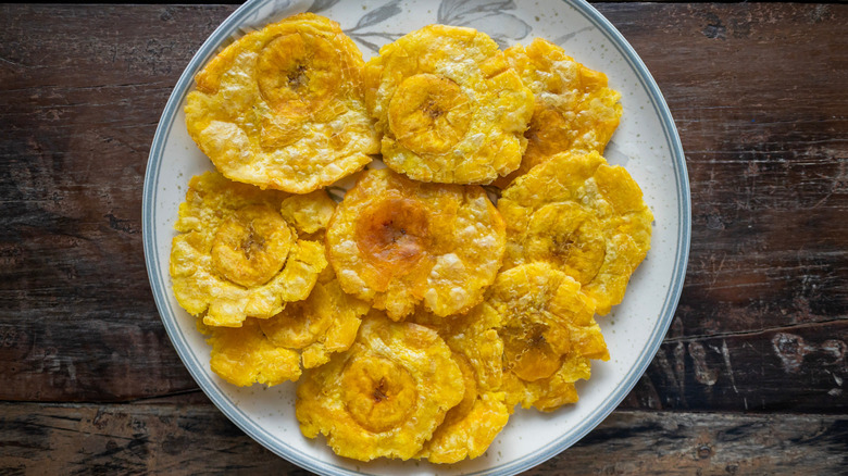 Tostones or patacones, a popular snack and side dish in latin american cuisine, served on a ceramic plate
