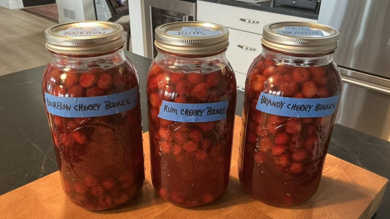 Cherry bounce in labeled jars on kitchen table