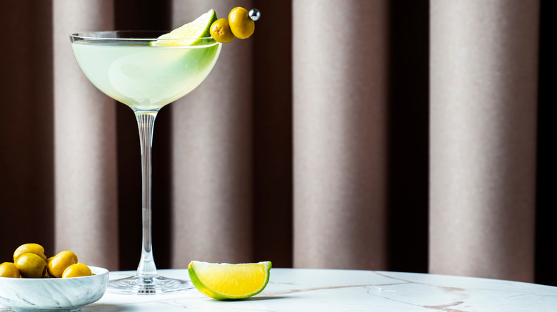 Mexican martini in martini glass with olives and lime