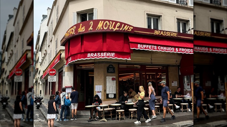 People gather and sit outside Café des 2 Moulins