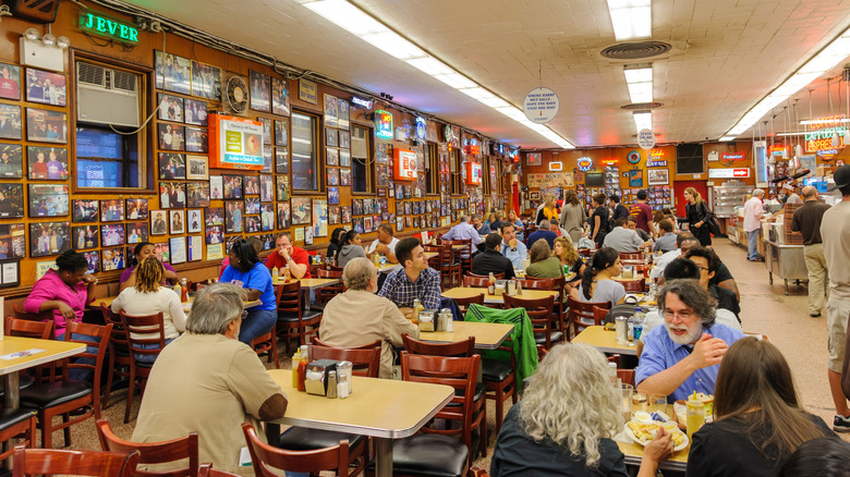 Customers dine at tables inside a busy Katz's Delicatessen