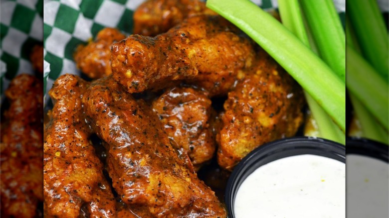 XXX chicken wings with celery sticks and dip on the side