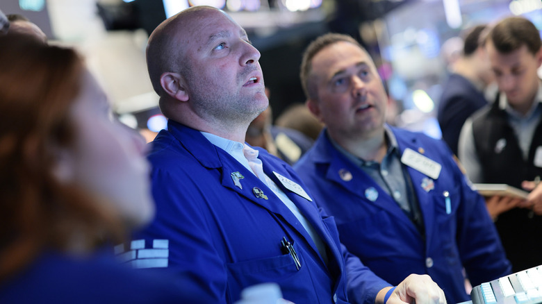 Traders on the stock exchange floor watching a screen