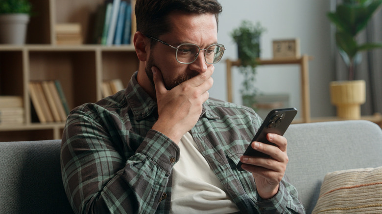 Man seeming shocked at something on his phone