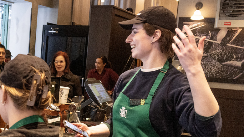 Starbucks barista on their phone while behind the counter