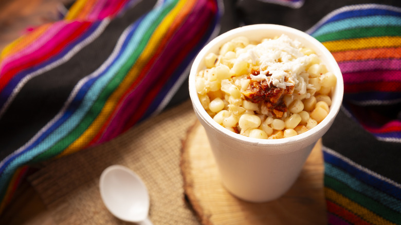 White styrofoam cup of esquites, creamy cooked corn