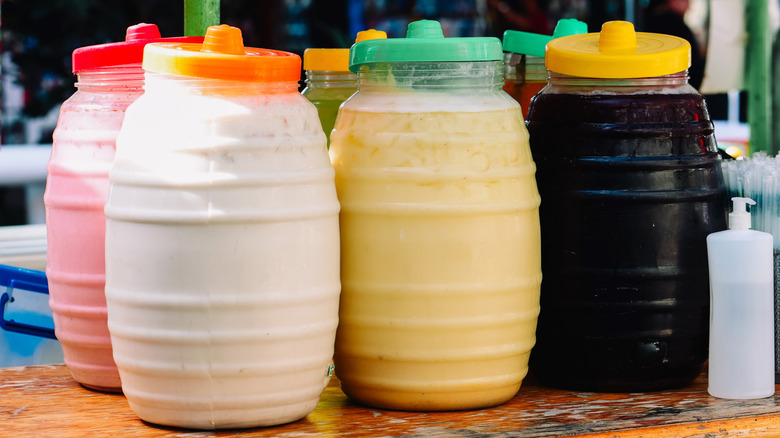 Jugs of Mexican aguas frescas, including horchata