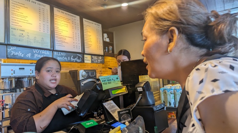 Woman customer ordering coffee from a female barista at Starbucks