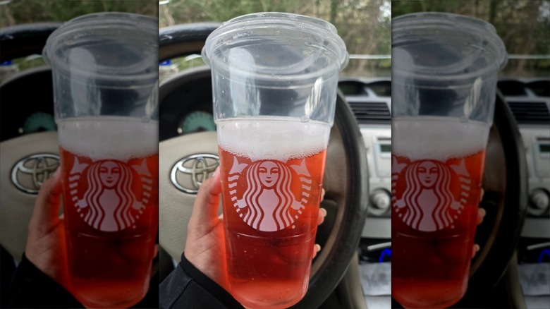 Hand holding Starbucks Refresher with no ice