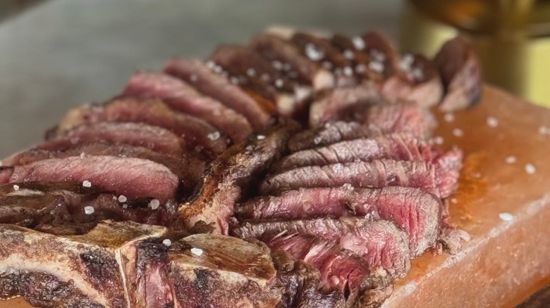 Salt-flecked, sliced steak arranged on a cutting board.