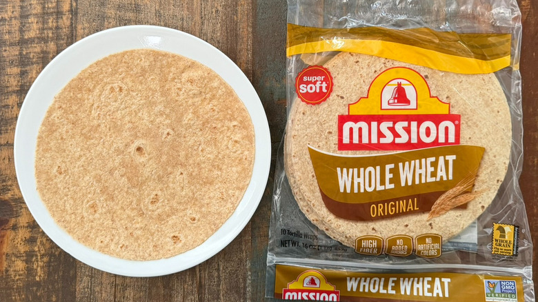 A package of Mission Original Whole Wheat Flour Tortillas next to a tortilla on a plate