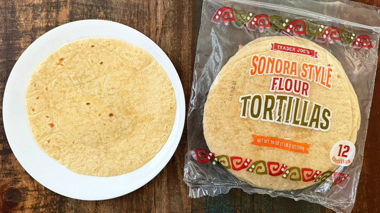 A package of Trader Joe's Sonora Style Flour Tortillas next to a tortilla on a plate