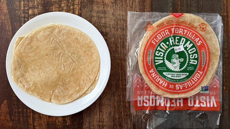 A package of Vista Hermosa Flour Tortillas next to a tortilla on a plate