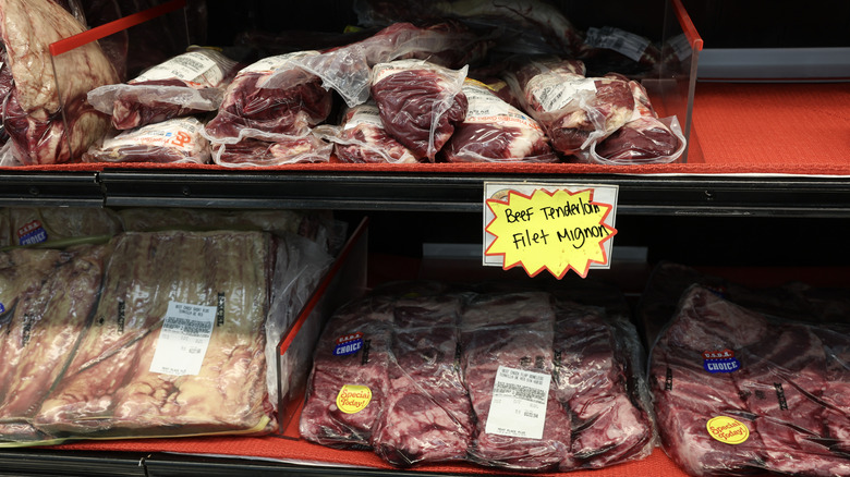 Packaged meat with yellow stickers on shelf at grocery store