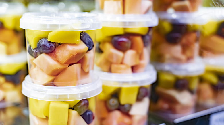diced melon pineapple and grapes in clear plastic container on store shelf