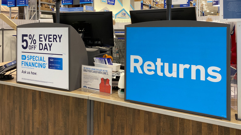 Sign on a counter reading "Returns" next to a sign specifying 5% off every day