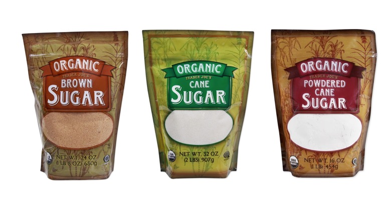 Bags of Trader Joe's Organic Brown Sugar, Organic Cane Sugar, and Organic Powdered Cane Sugar on white background