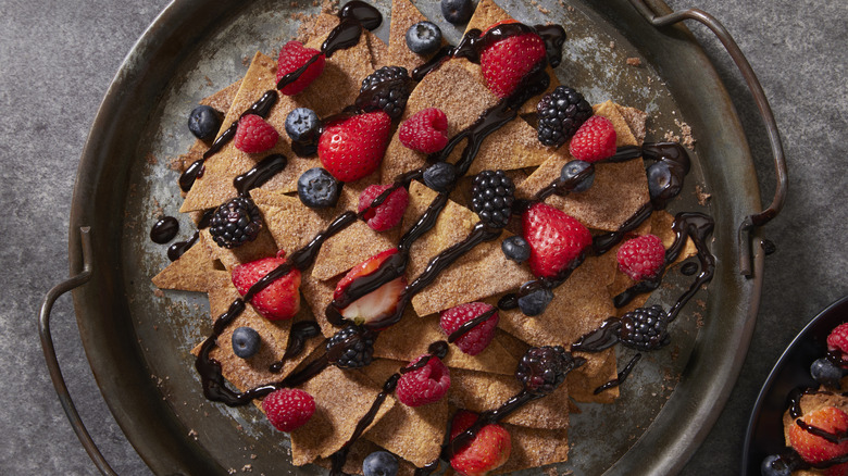 Cinnamon sugar dessert nachos topped with berries and chocolate