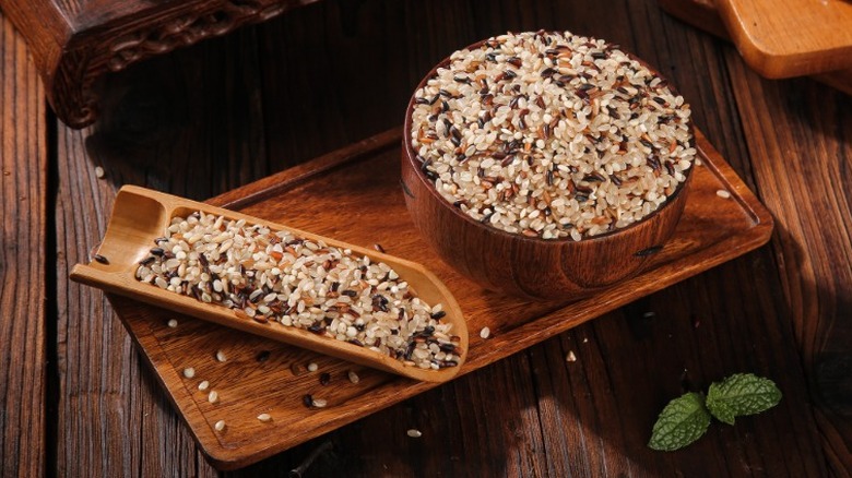 A bowl of various grains on a wooden tabletop