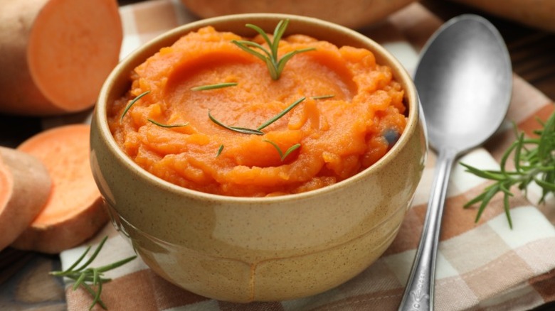 Bowl of mashed sweet potatoes with spoon