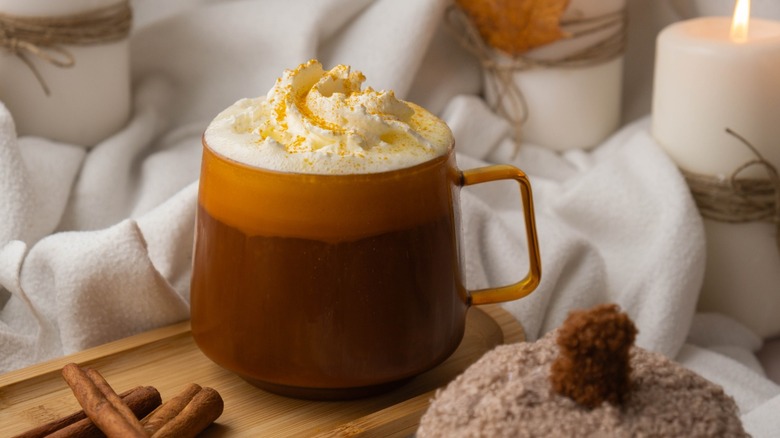 Pumpkin spiced latte morning warming coffee. Fall Drinks for Halloween Thanksgiving Holiday beverage Autumn spicy cinnamon flavor seasonal hot drinking in cozy orange cup. Atmosphere of cold rainy