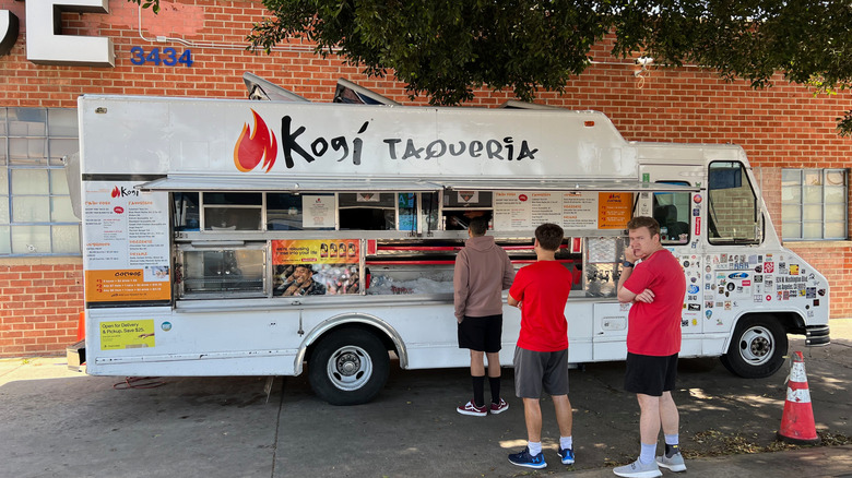 Exterior of a Kogi food truck in Los Angeles with customers waiting