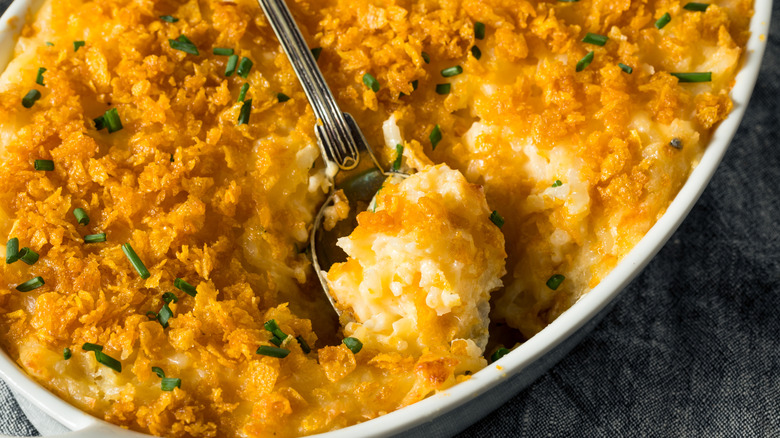 Spoon dipping into dish of funeral potatoes
