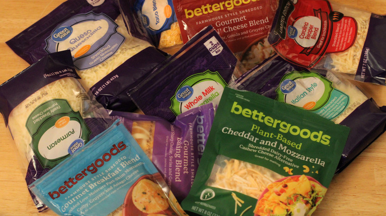 A random scattered pile of different bags of shredded cheese from Walmart's Bettergoods and Great Value Brands