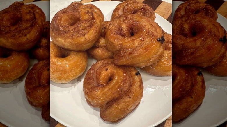 a stack of cinnamon roll donuts on a white plate