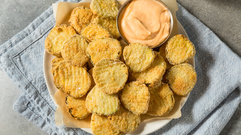 overhead shot of homemade fried pickles on plate with sauce