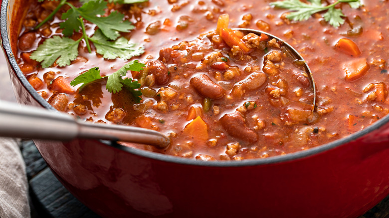ladle dipped in pot of chili