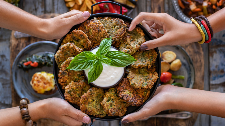 women sharing lentils in black pan