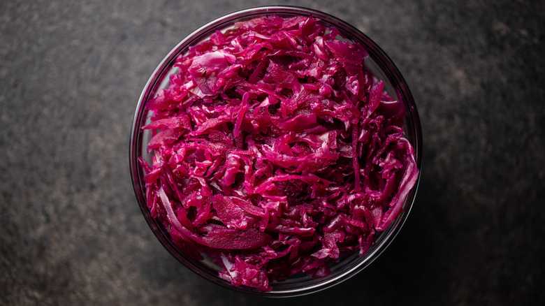 Red sauerkraut in bowl on black table