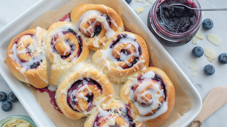 closeup of berry sweet rolls with icing drizzle
