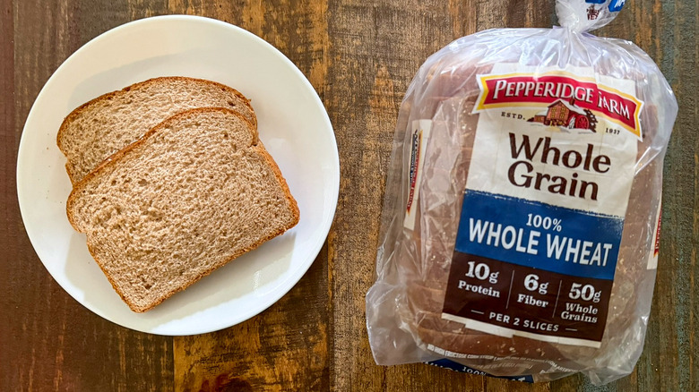 Two slices of Pepperidge Farm Whole Grain 100% Whole Wheat bread next to a loaf of the same bread