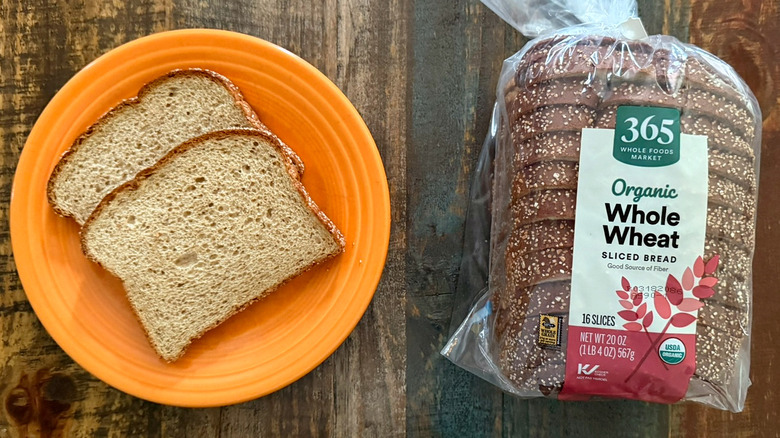 Two slices of Whole Foods Market 365 Organic Whole Wheat Sliced bread next to a loaf of the same bread