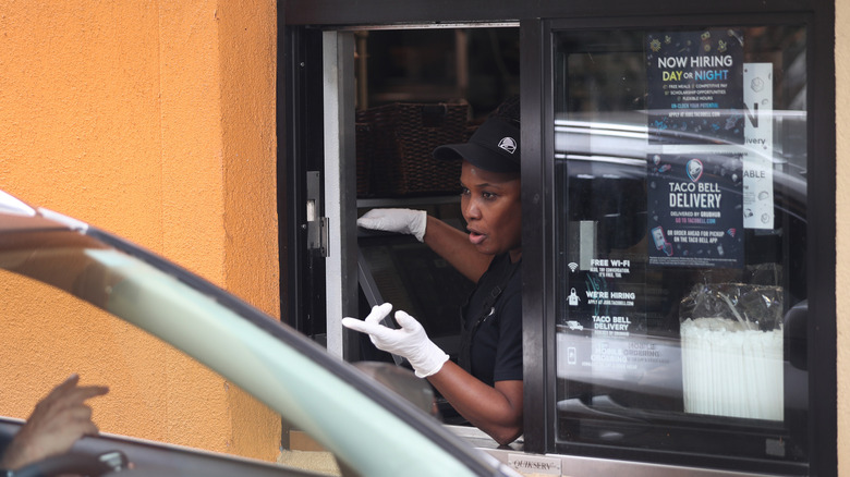 A Taco Bell worker taking a drive-thru order