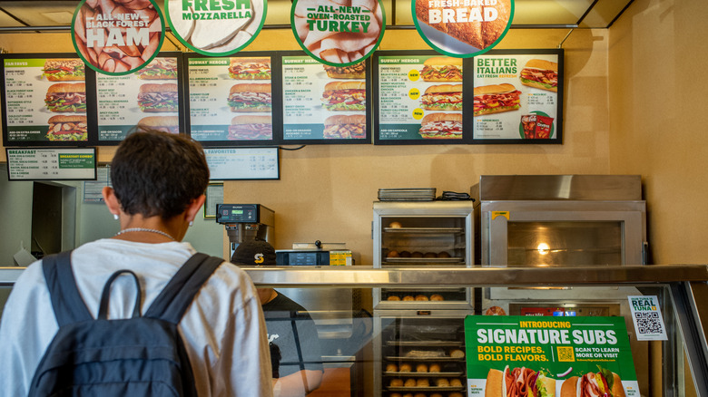 A customer ordering at Subway