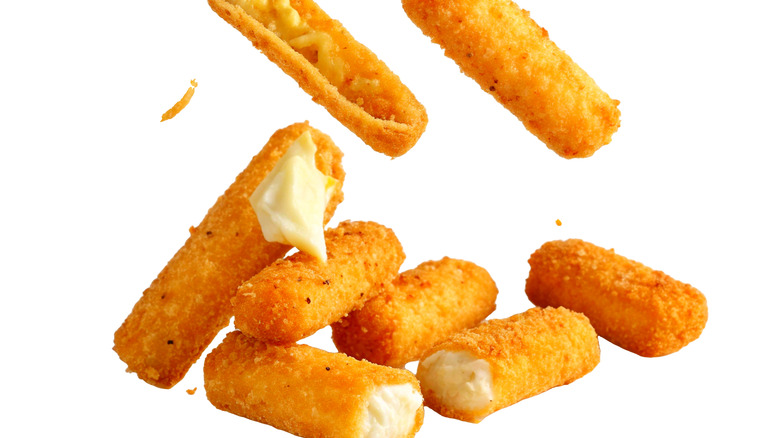 Mozzarella sticks falling against a white background