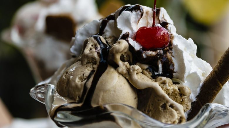 chocolate ice cream sundae in a glass with a cherry on top